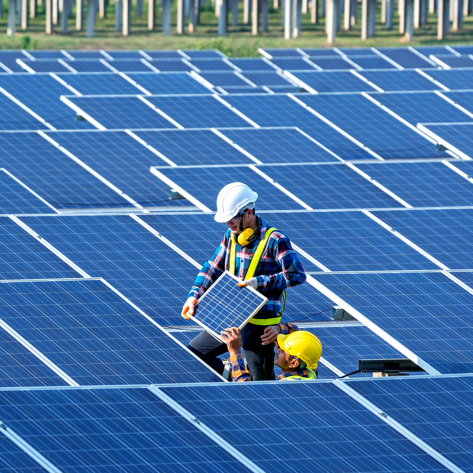 Workers installing solar panels on the roof
