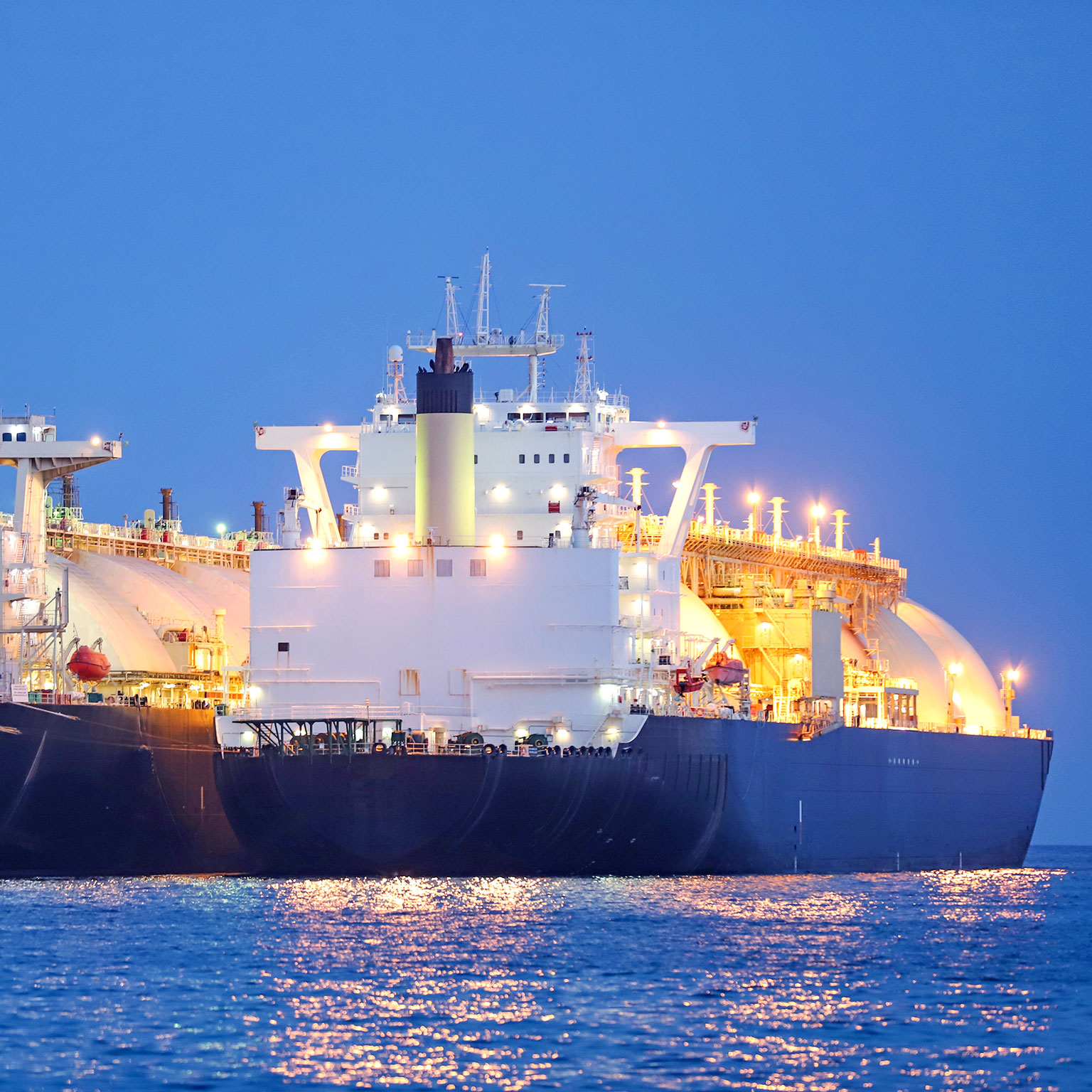 A liquified natural gas tanker supplying gas to a floating storage unit ship (LNG FSU) - stock photo