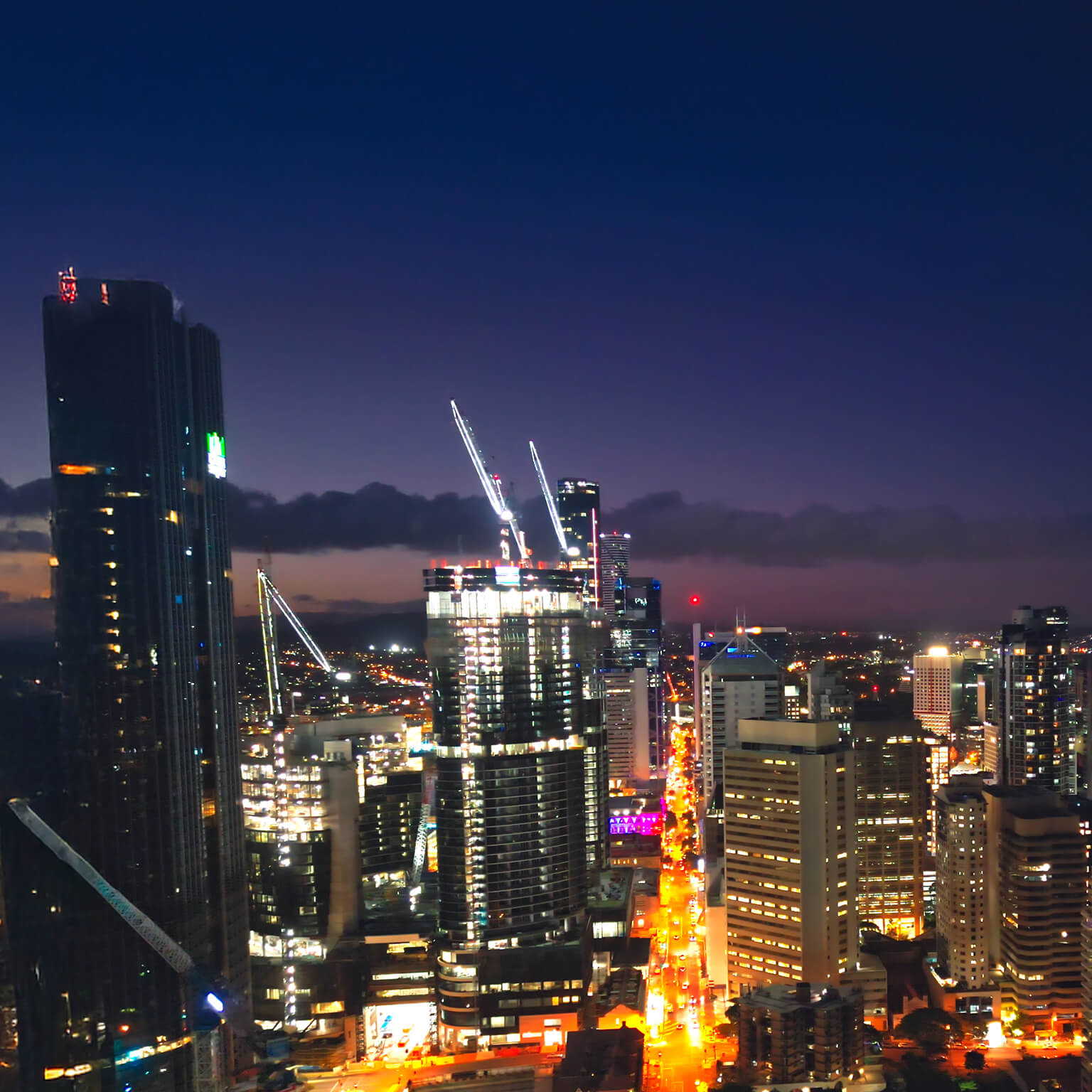Aerial view Real time Footage of above Brisbane river over Kurilpa Bridge, Victoria Bridge and Captain Cook Bridge beside Modern Office Building at night time in Brisbane, Queensland, Australia, Business Financial Industry and Travel Destination Concept