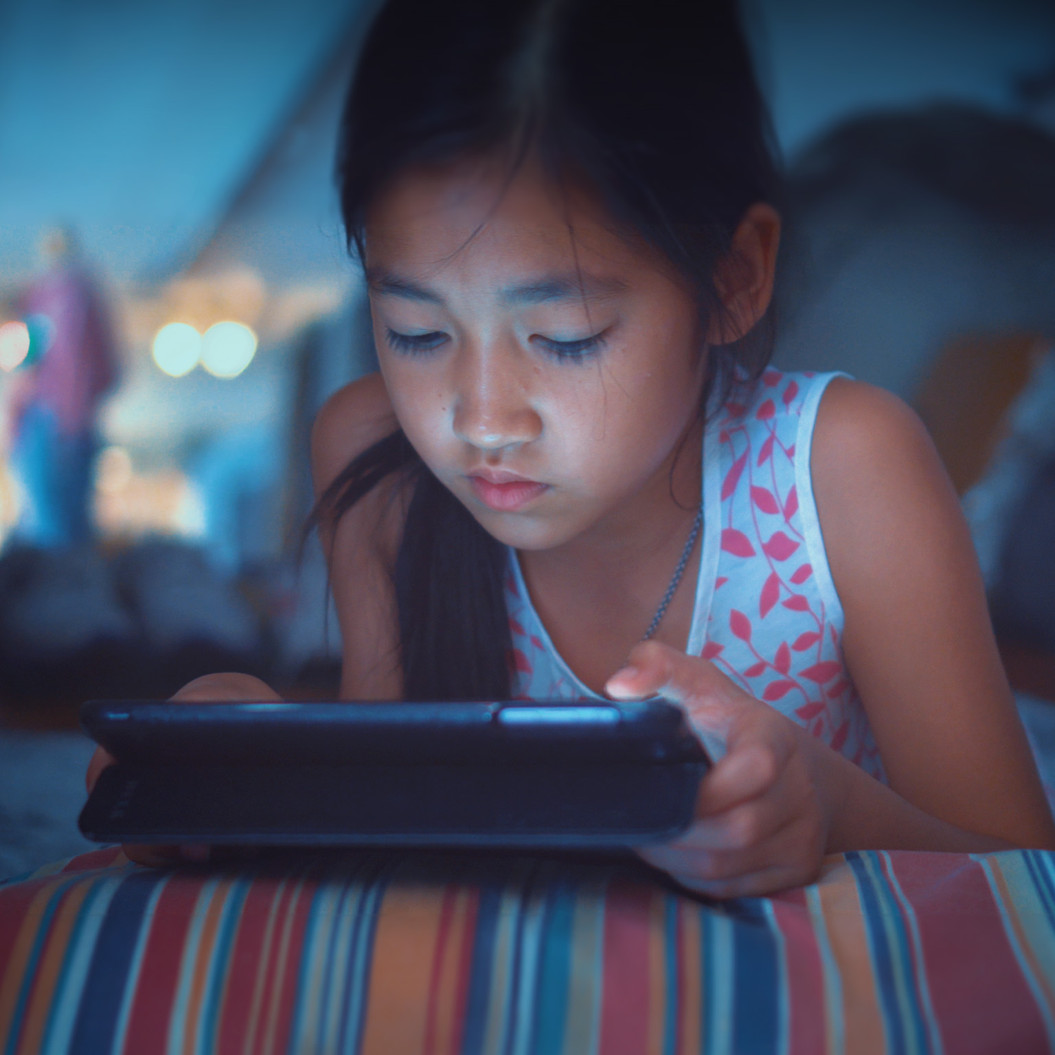 Close-up of little girl using tablet at night