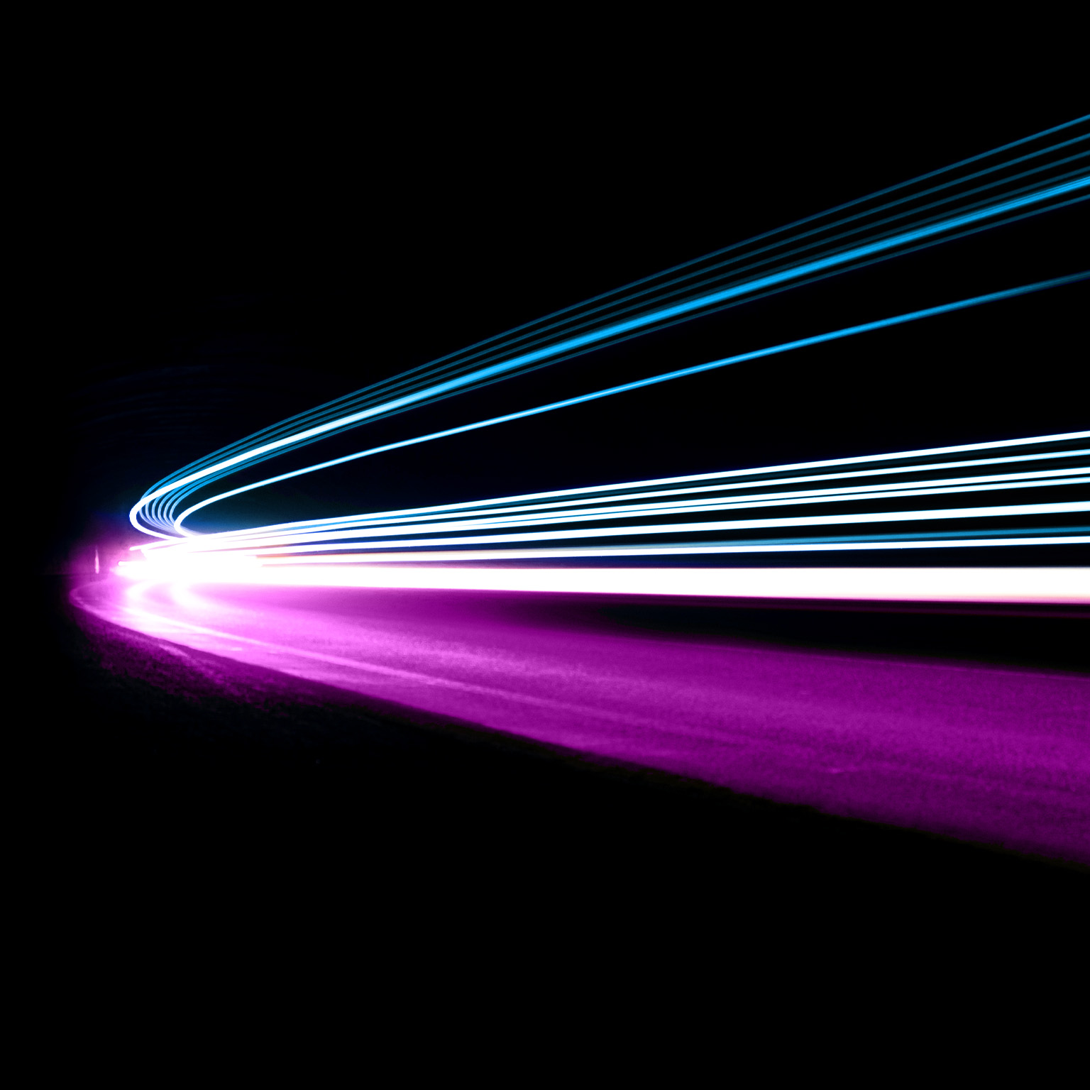 The blue, white, and purple light trails move in unison, giving the impression of coordinated movement and speed.