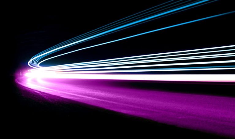 The blue, white, and purple light trails move in unison, giving the impression of coordinated movement and speed.