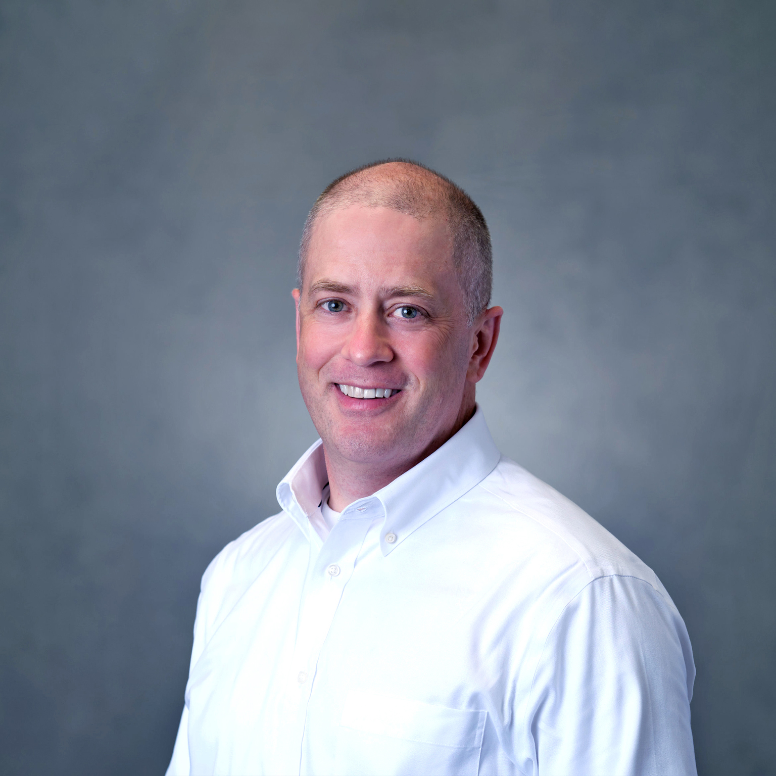 Andrew Rose in white shirt with gray background