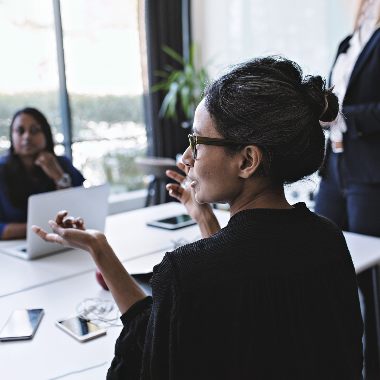 Businesswoman gesturing while in discussion with colleagues