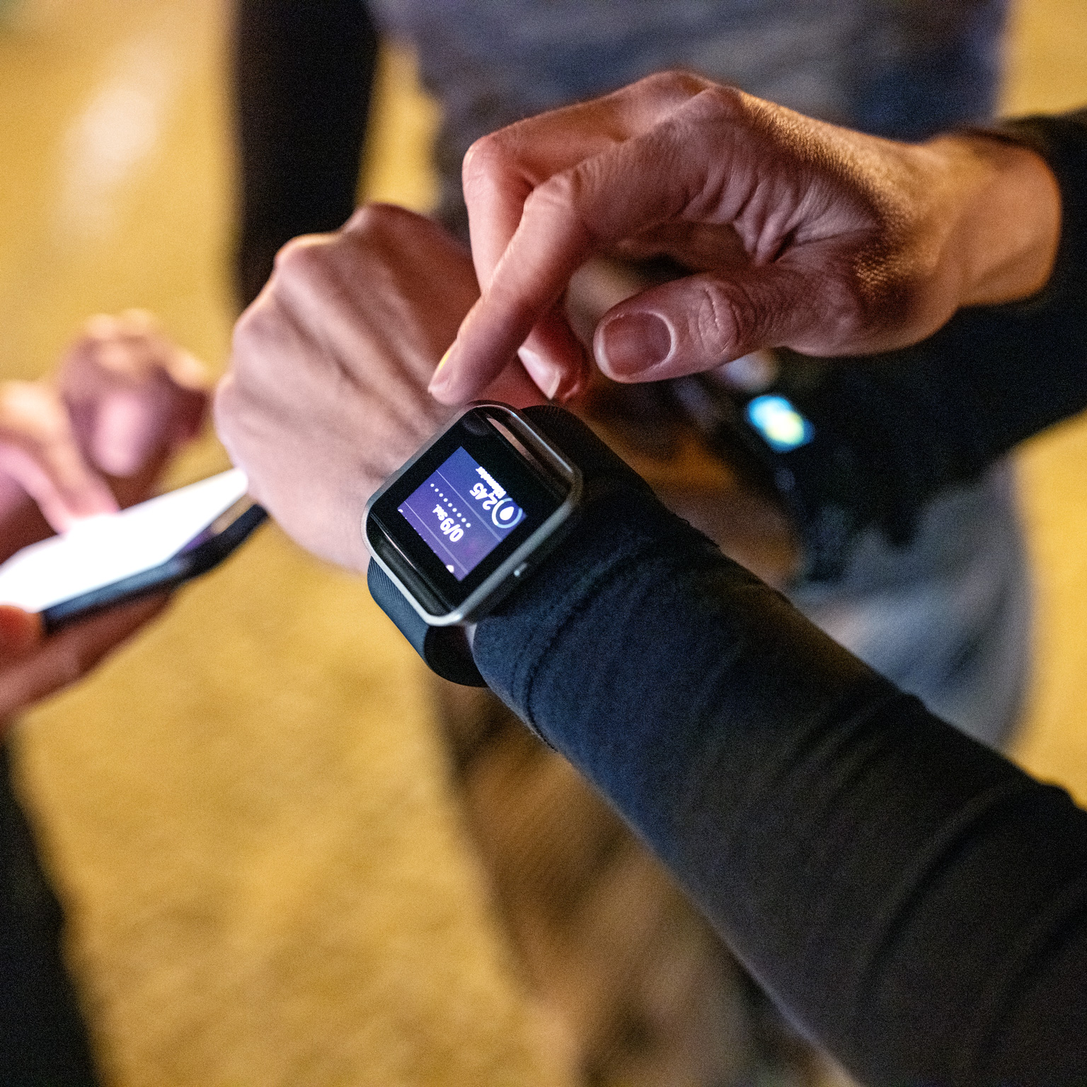 Close-up of young people standing together using their smart devices after a workout session.