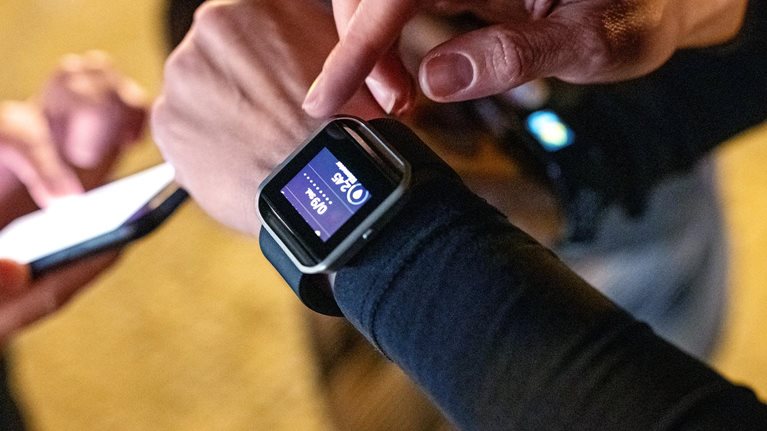 Close-up of young people standing together using their smart devices after a workout session.