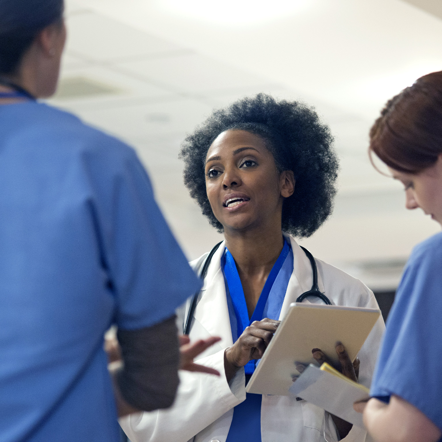 Image of a medical team with women in it having a stand-up meeting at a hospital.