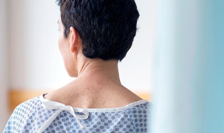 Rear view of senior woman wearing hospital gown