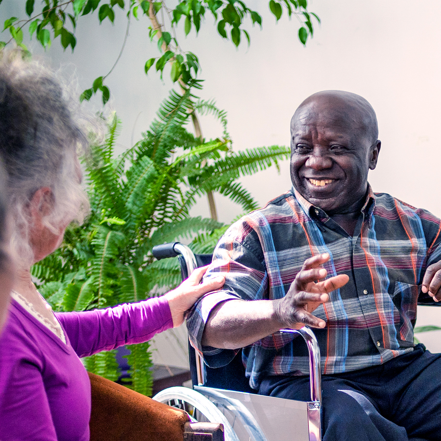 A group of diverse older people chatting with a counsellor during a therapy session in a residential care home