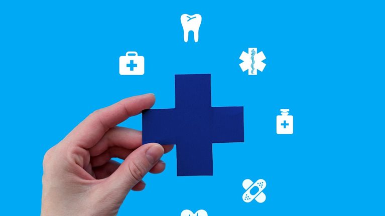 A hand holds a blue medical cross against a bright blue background. Surrounding the cross are various white medical icons, symbolizing comprehensive healthcare services.