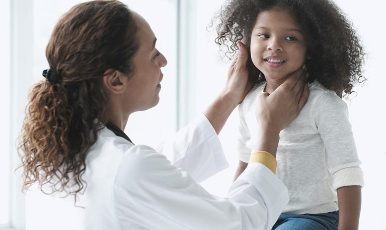Doctor examining girl in office - stock photo
