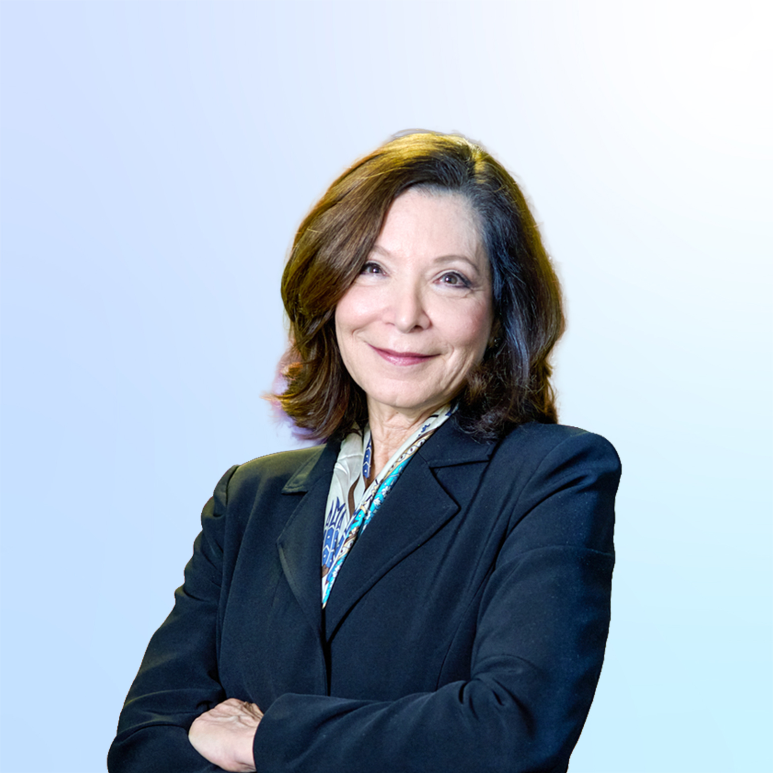 Leslie Davis wearing a blue jacket, arms folded, warmly smiling.