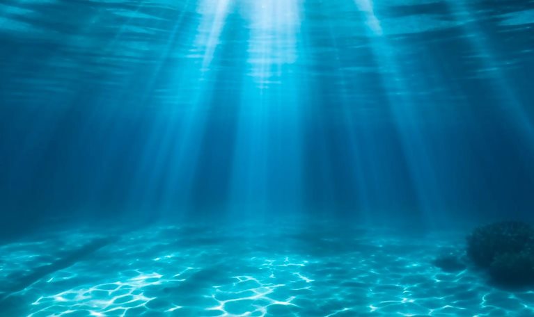 Underwater ocean. Deep sea water abyss with blue sun light from surface. - stock photo