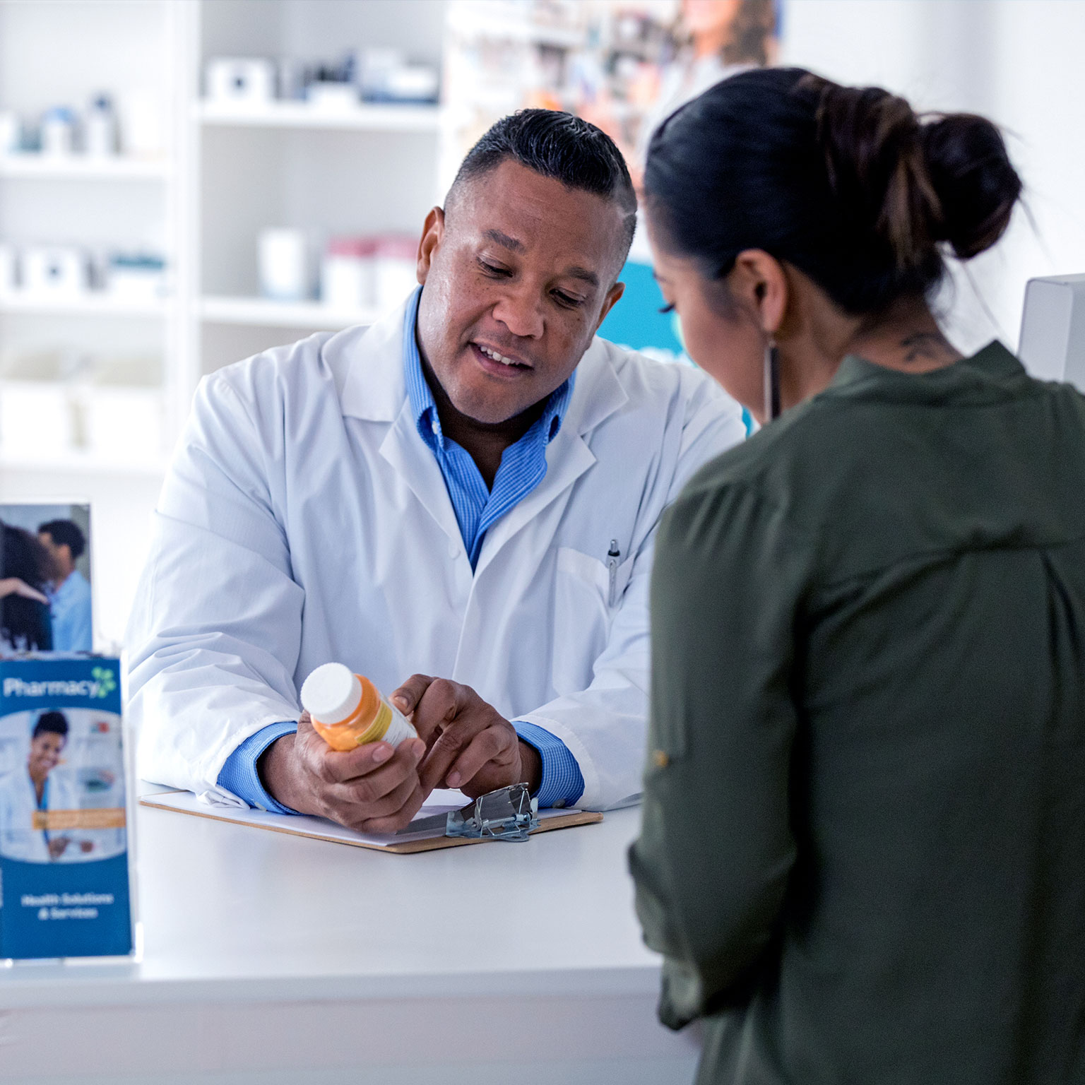 Pharmacist explaining to a customer across the pharmacy counter