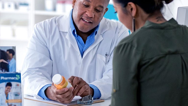 Pharmacist explaining to a customer across the pharmacy counter