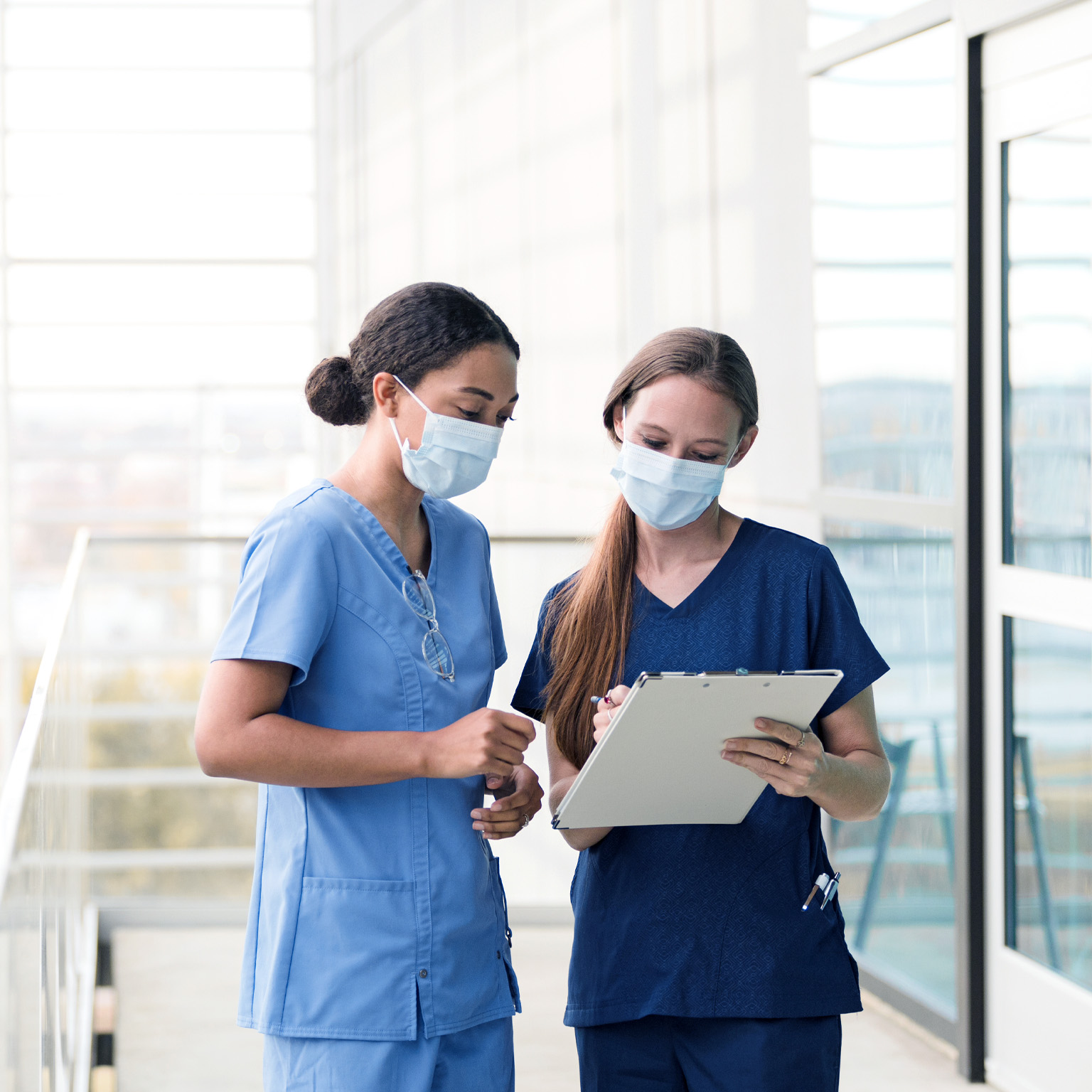 Two female surgeons confer before seeing patients in the hospital