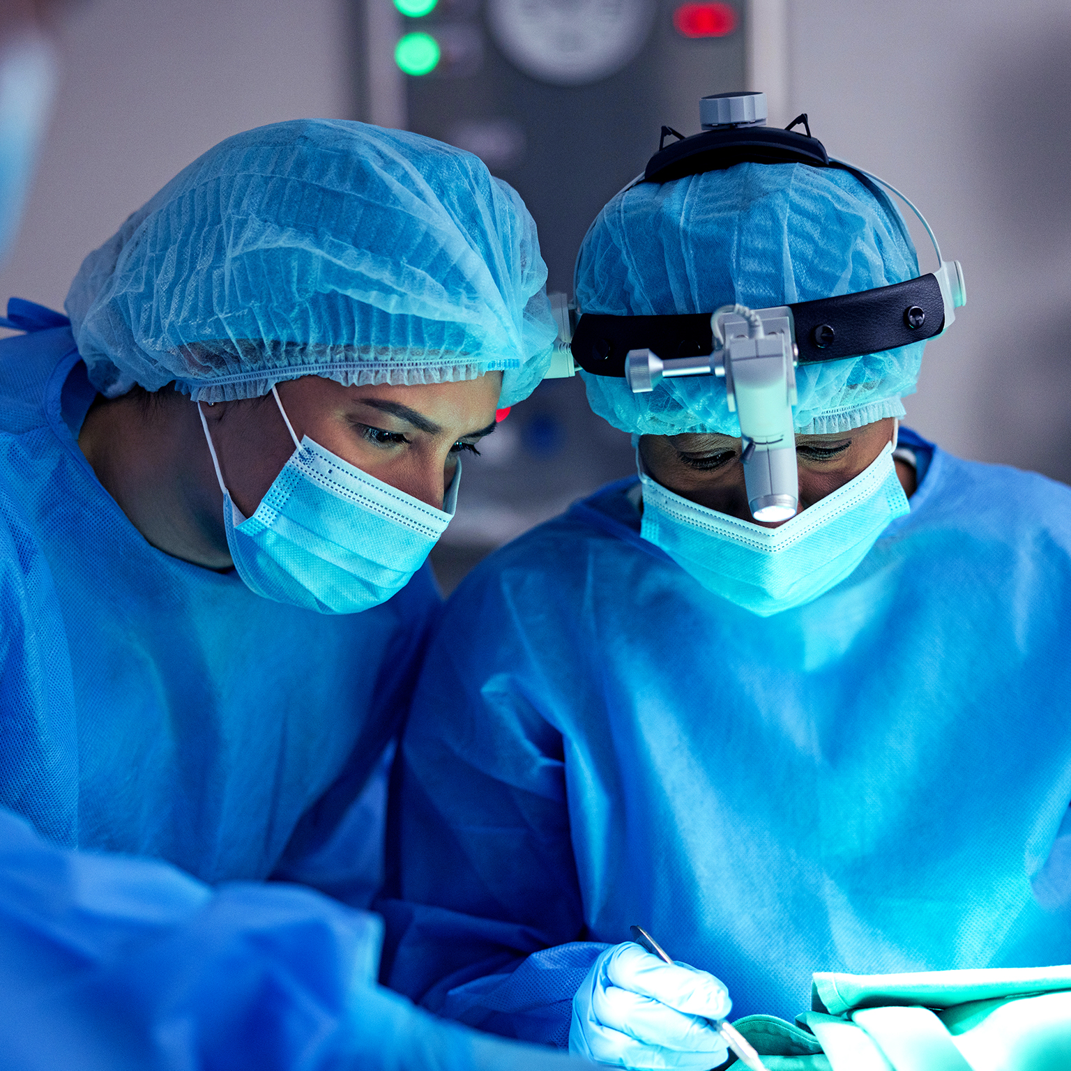 Surgeon, doctor and team in operating room for surgery, face mask or PPE for safety and healthcare at hospital. Help, support and medical procedure with medicine, trust with partner and treatment