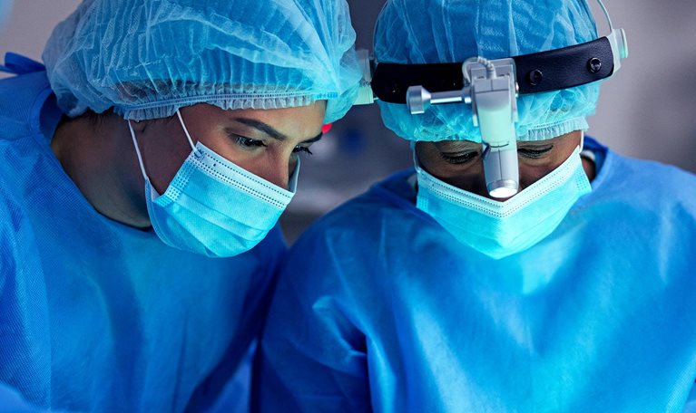 Surgeon, doctor and team in operating room for surgery, face mask or PPE for safety and healthcare at hospital. Help, support and medical procedure with medicine, trust with partner and treatment