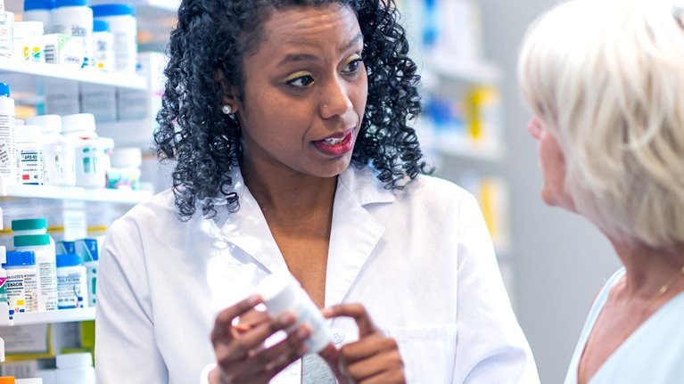 Female pharmacist assisting woman in pharmacy