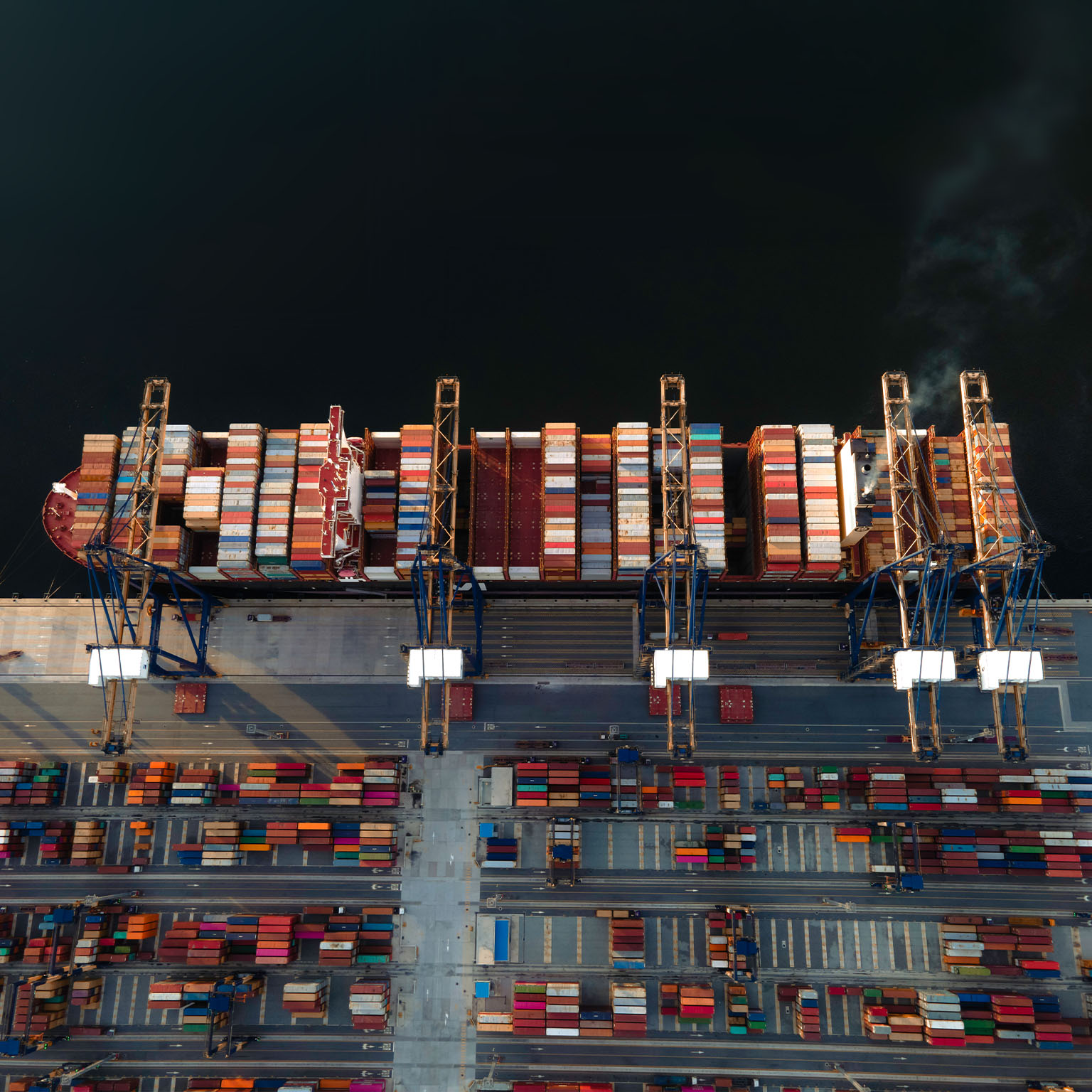 The largest TEU top 5 of the world container vessel in the condition of alongside the terminal jetty wharf of the port, load and discharging units of container shipment in port yard for transport services to Worldwide under logistics system networks