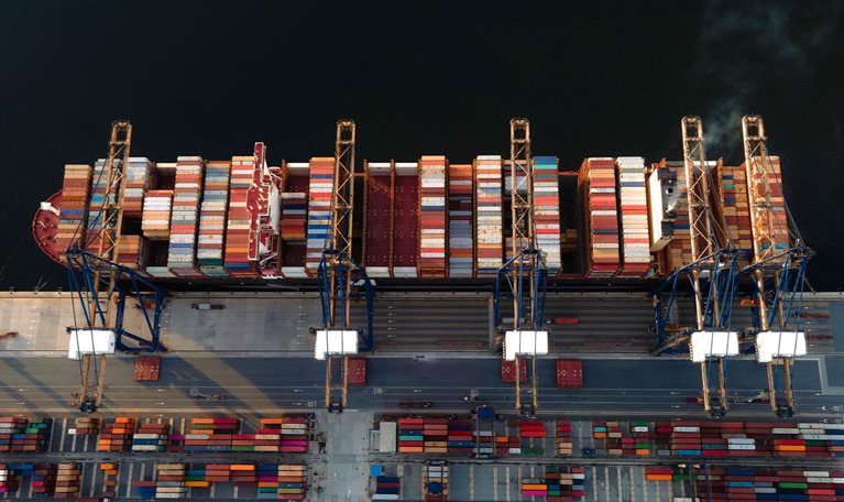The largest TEU top 5 of the world container vessel in the condition of alongside the terminal jetty wharf of the port, load and discharging units of container shipment in port yard for transport services to Worldwide under logistics system networks