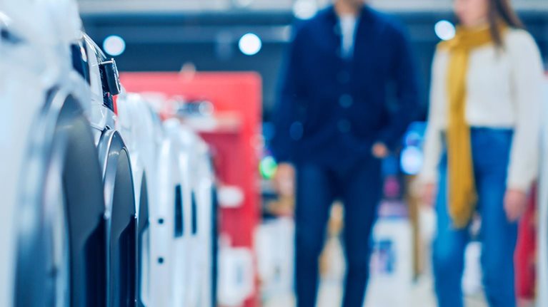 Customers explore modern laundry solutions in a retail shop.
