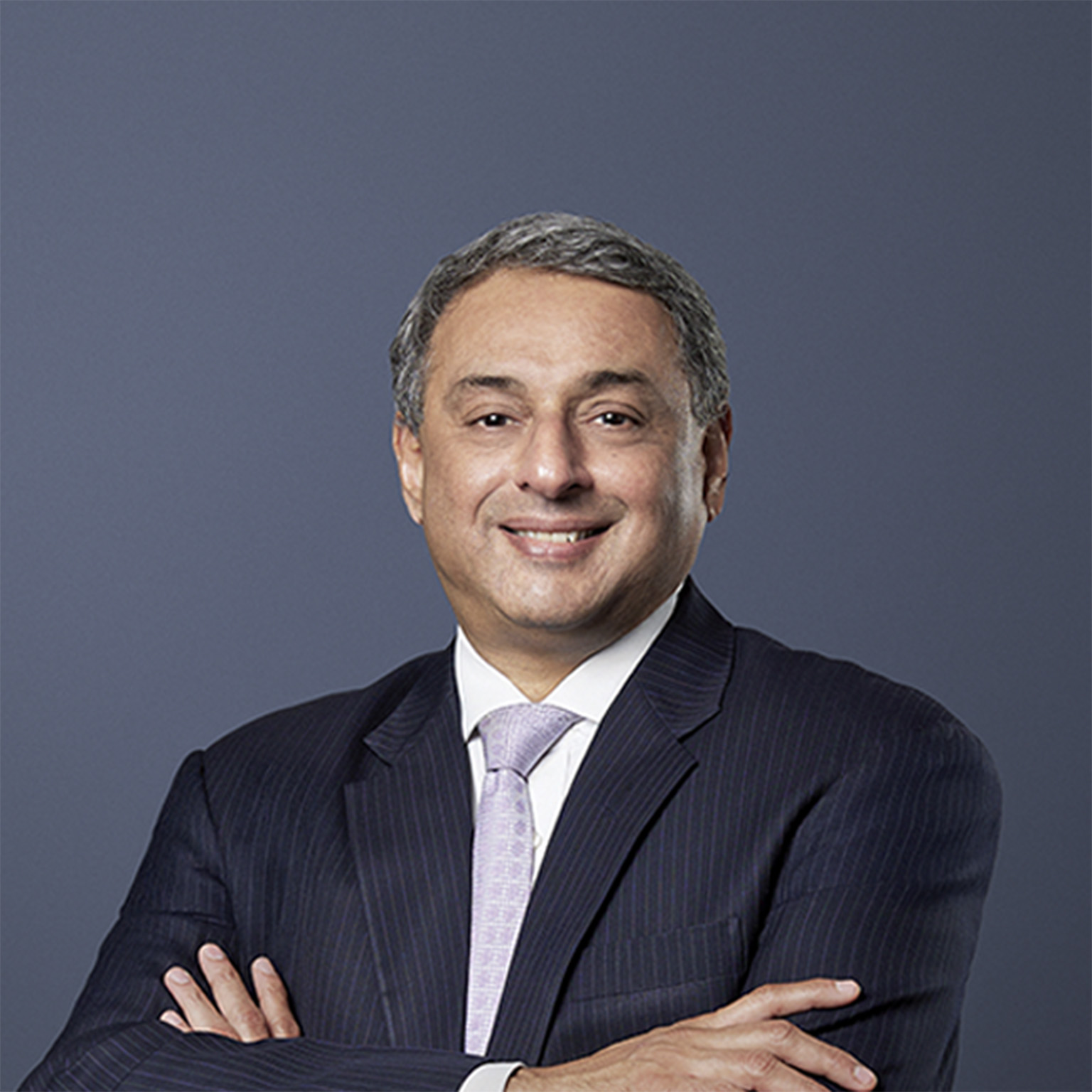 T. V. Narendran, CEO of Tata Steel, stands with a gentle smile, dressed in a dark suit and arms folded across his chest.