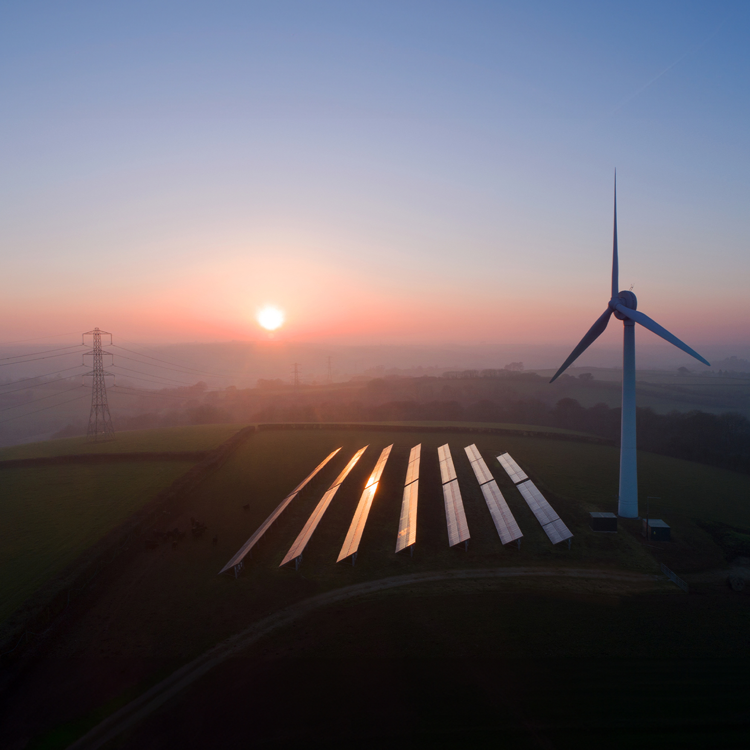 Solar panels and wind turbines in field - stock photo