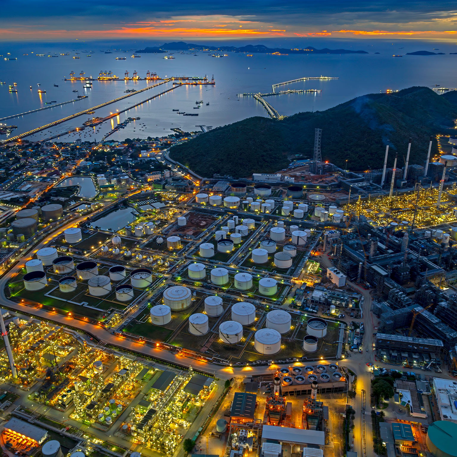 Aerial view oil refinery and fuel storage tanks at night time.