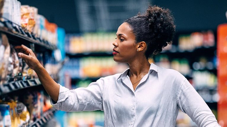 Woman Shopping in Supermarket Aisle Searching for Products