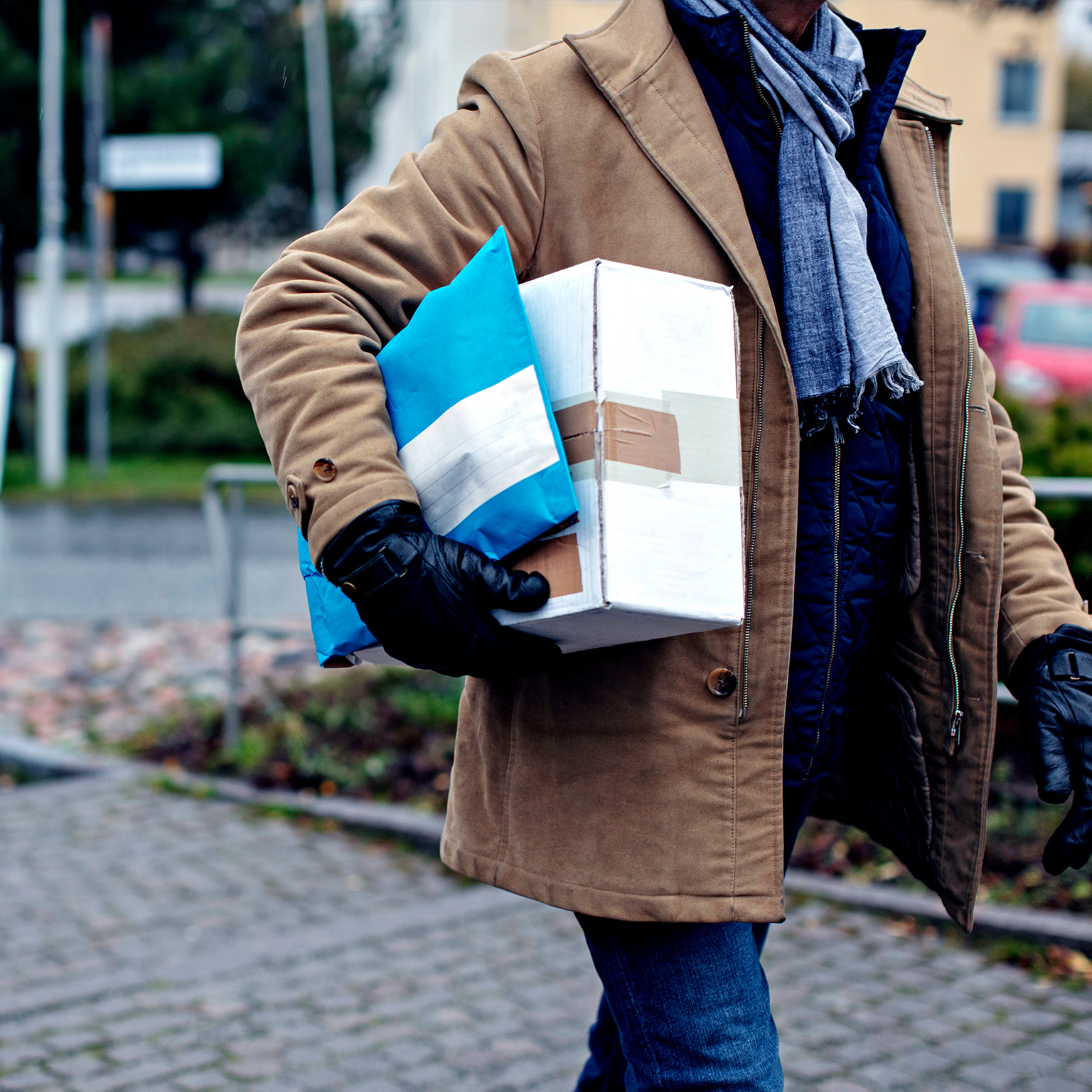 Midsection of senior man with package walking by sidewalk during winter - stock photo