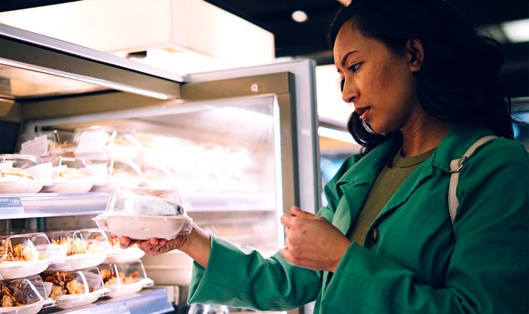 Woman buying packed food from cafe