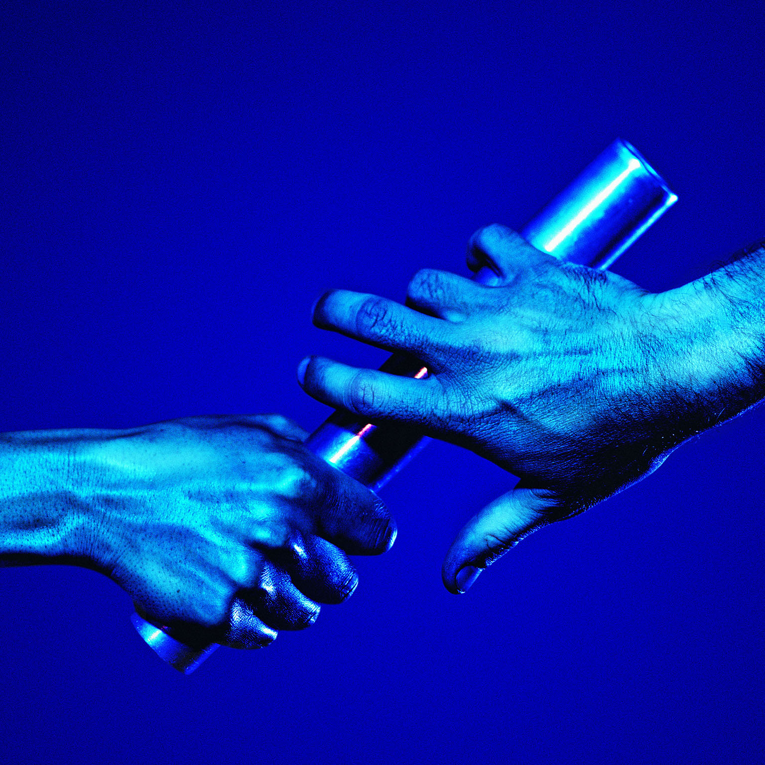 One hand passing a baton to the other