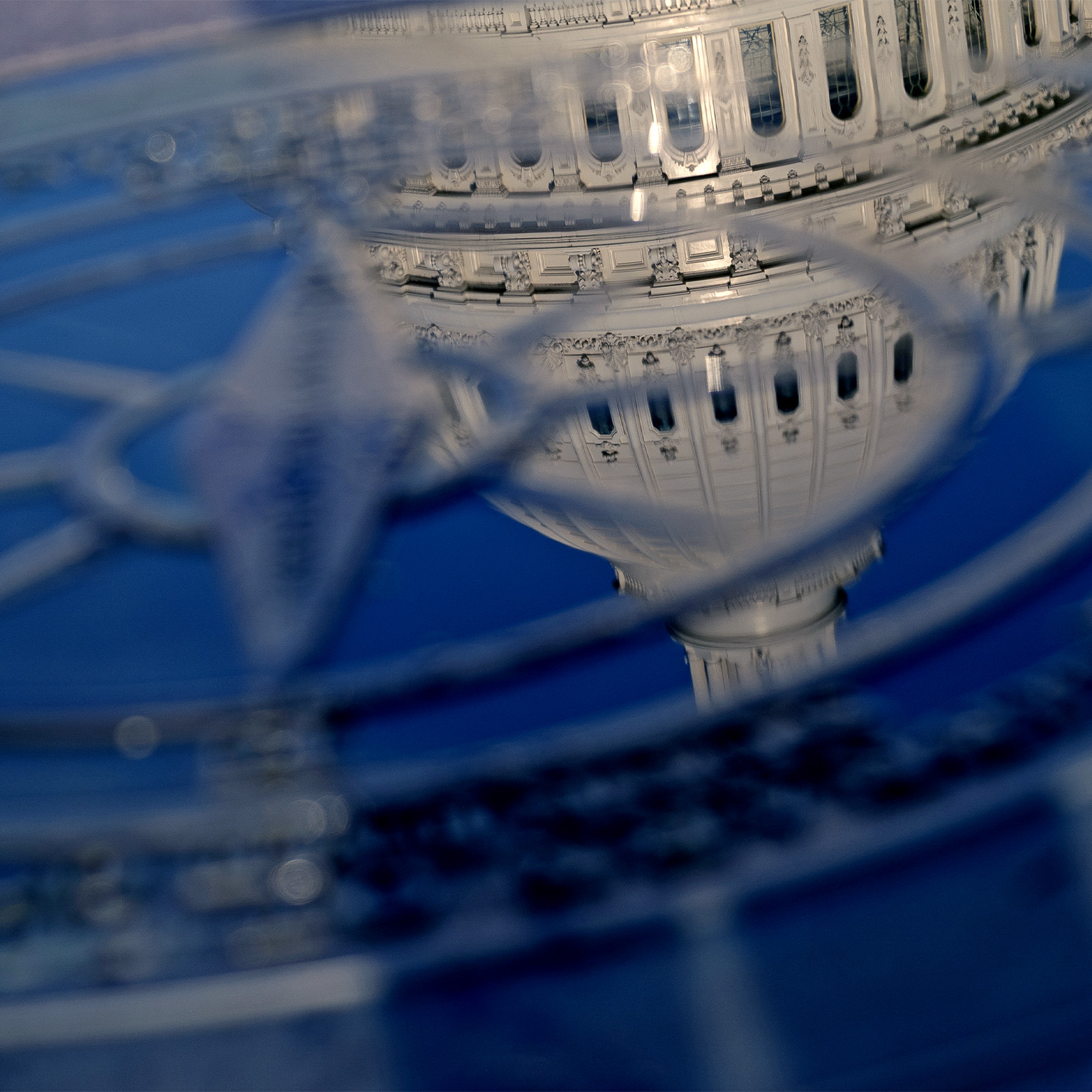 Close-up of the compass in the courtyard of the the U.S. Capitol Building with the domed top of the Capitol Building reflected in it.
