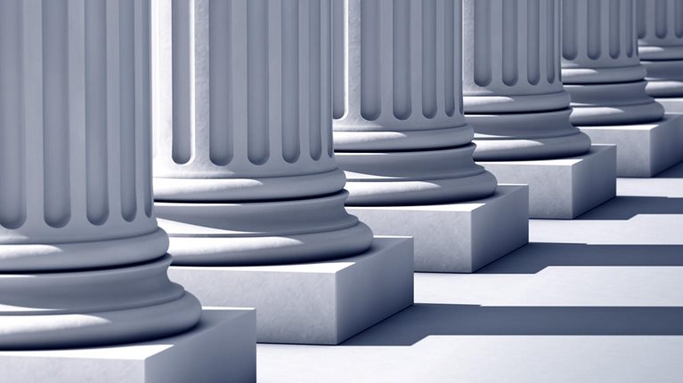A deep row of stone columns casting long, linear shadows.