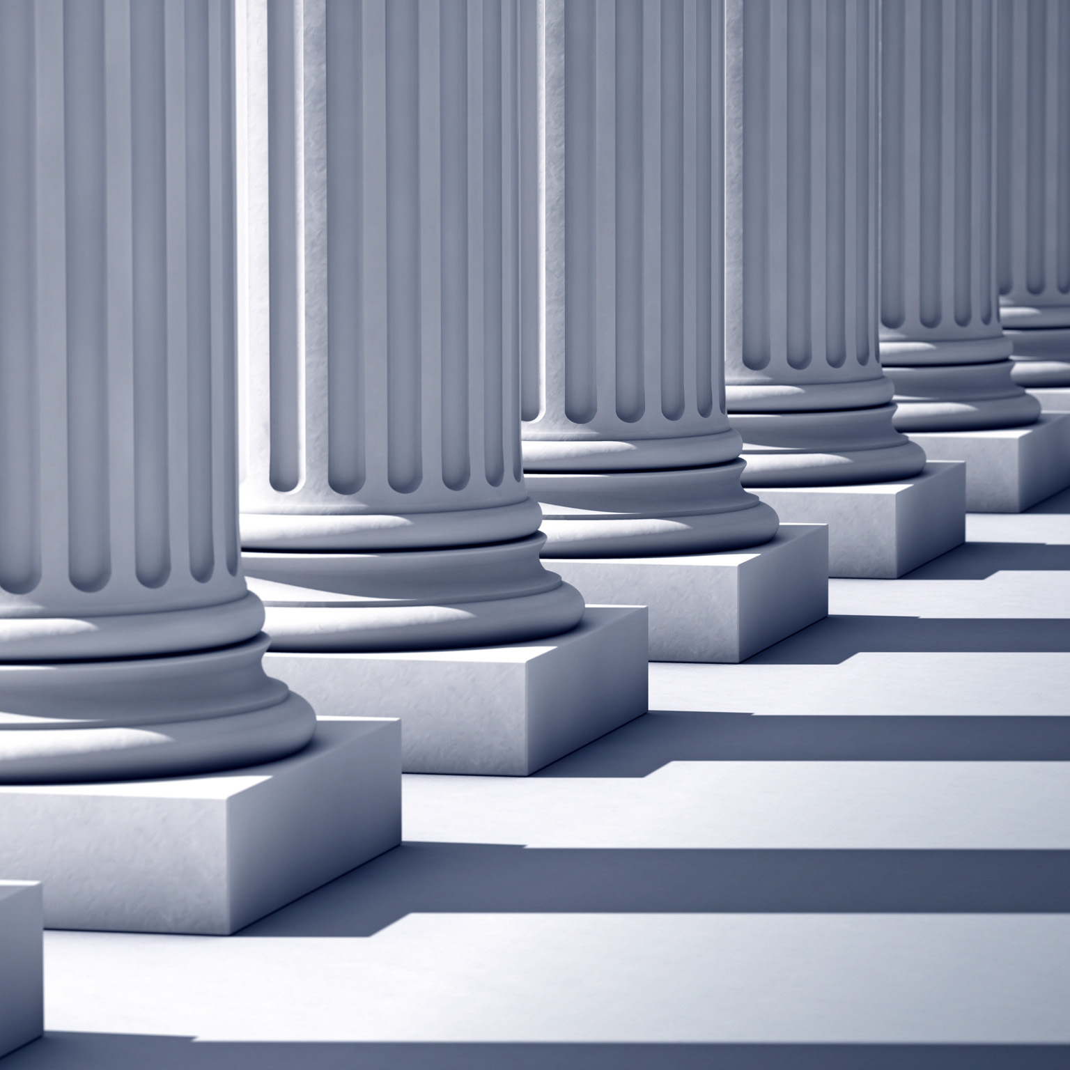 A deep row of stone columns casting long, linier shadows. 