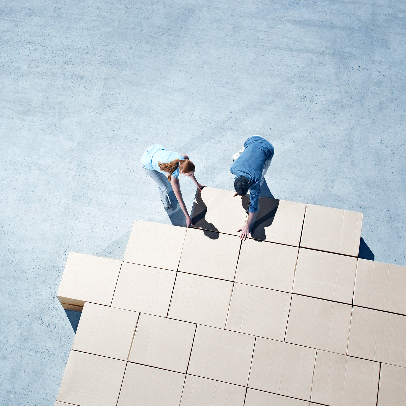 Couple building house outline on sidewalk - stock photo