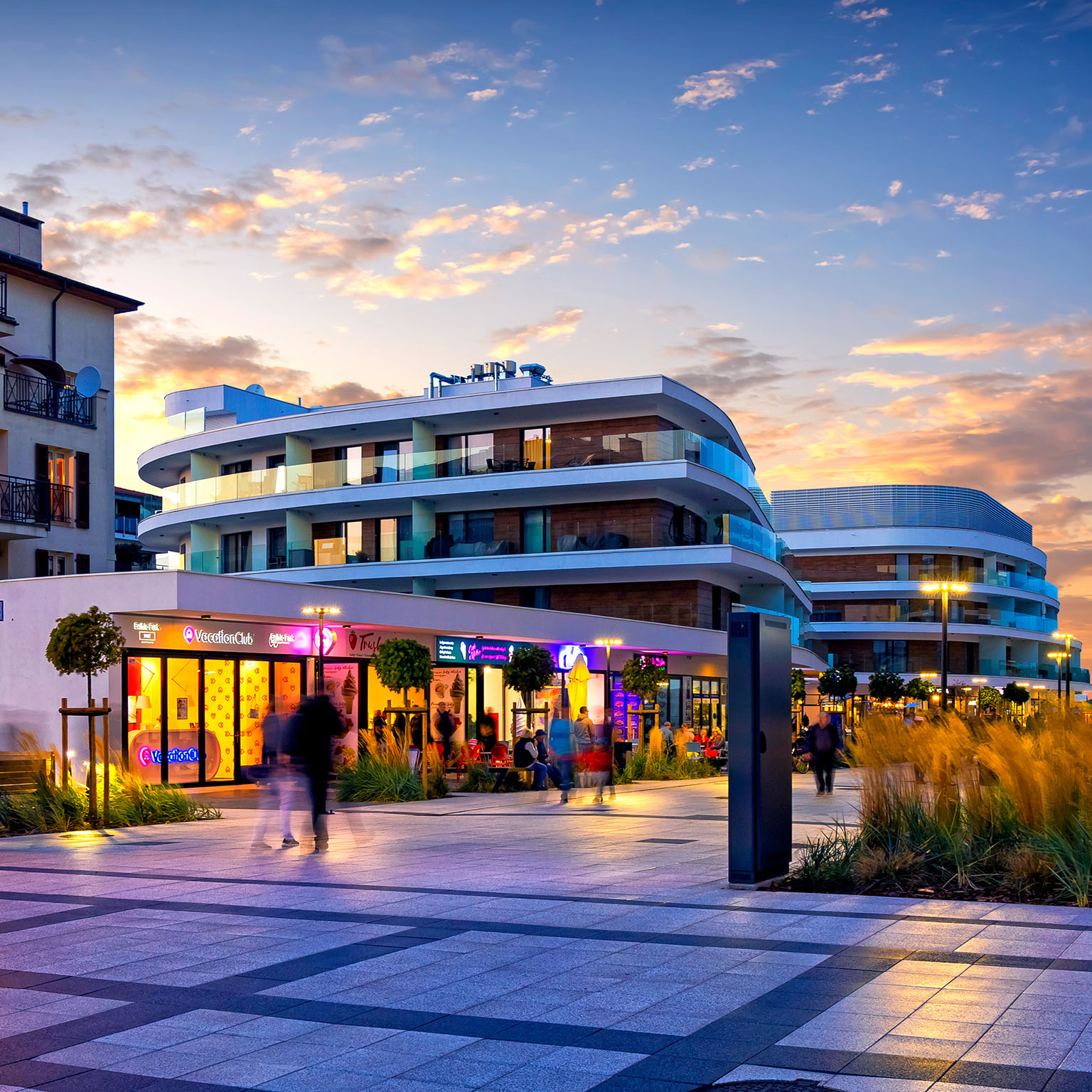 Evening view of a promenade surrounded by mixed-use real estate