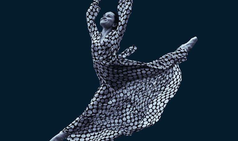 Dancing woman in dress in mid-air jump