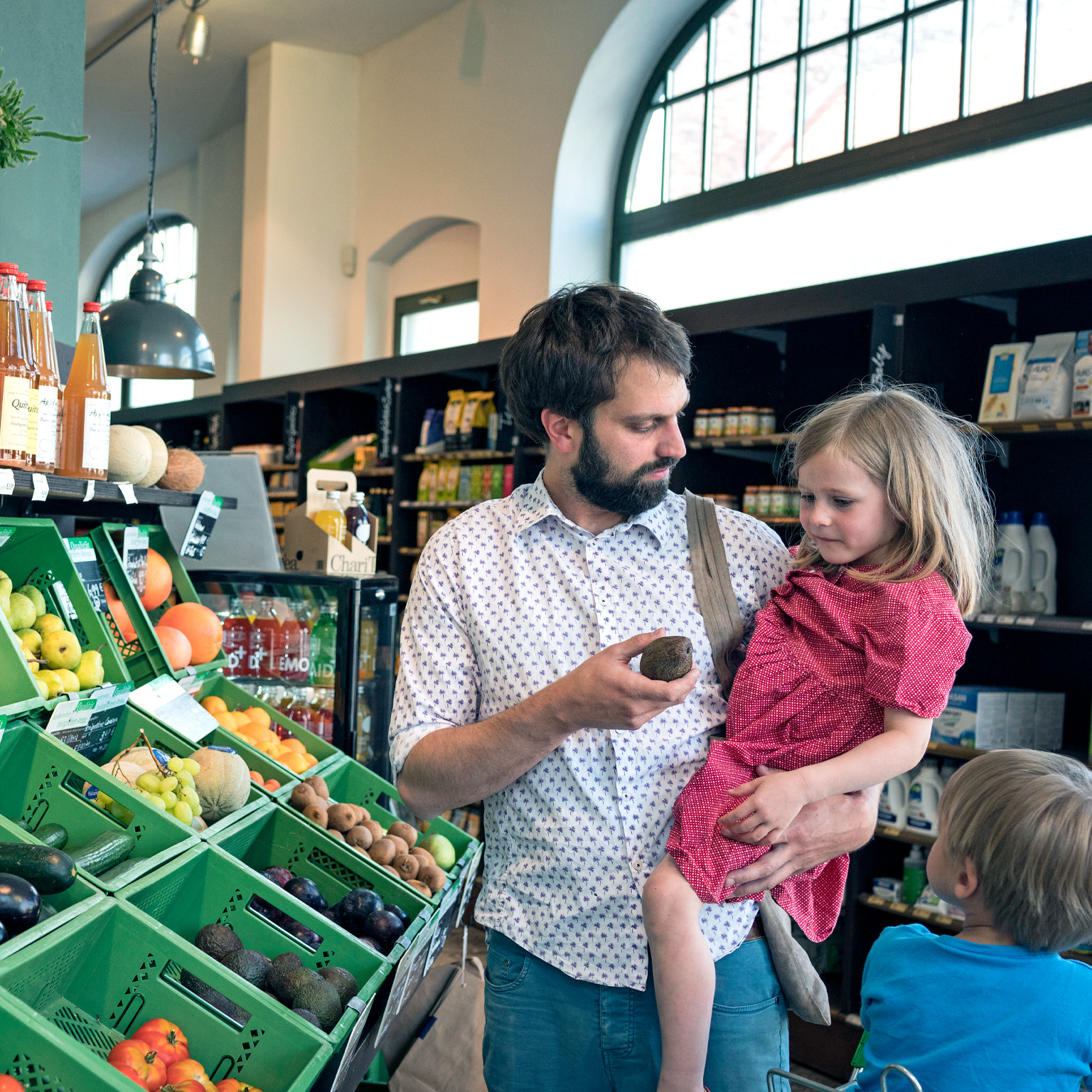 A father with his children in a retail store isle holding a displayed item