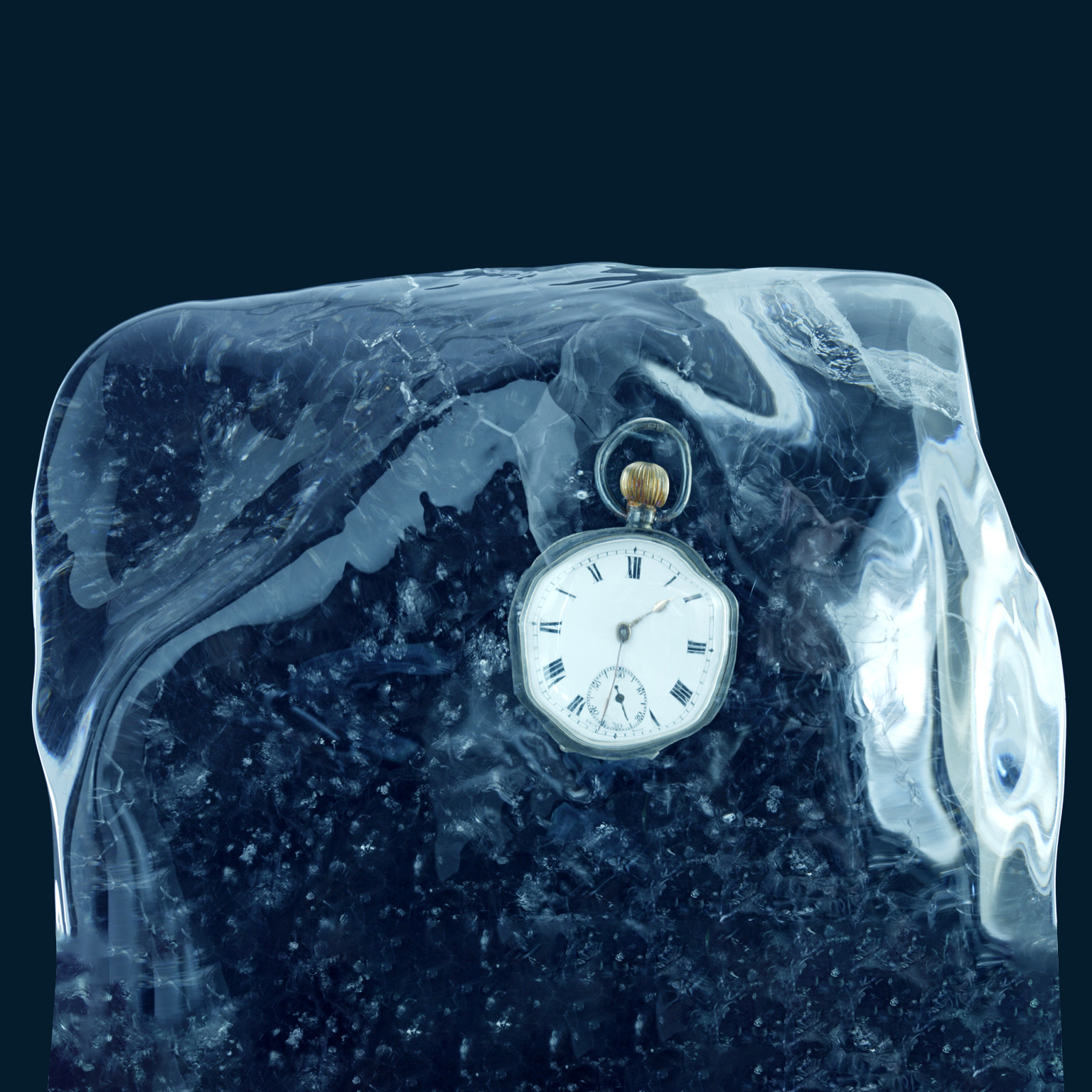 A pocket watch encased in a block of ice and set against a deep blue backdrop.