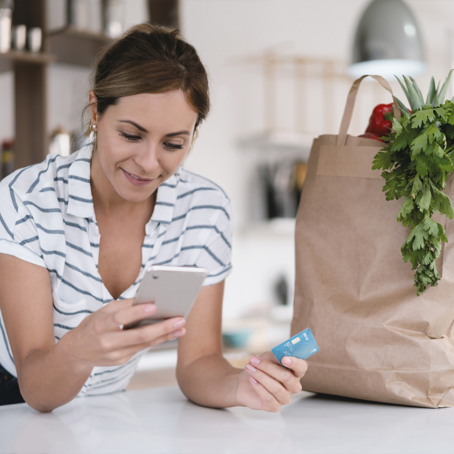 Woman at home paying online for a food delivery with a credit card
