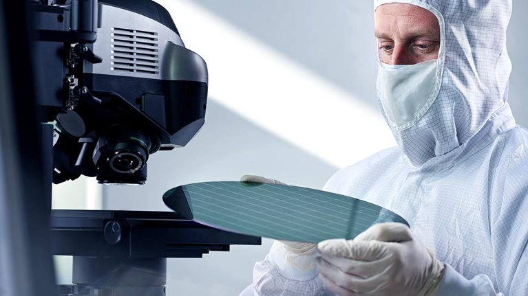 Engineer putting wafer chip on microscope in laboratory