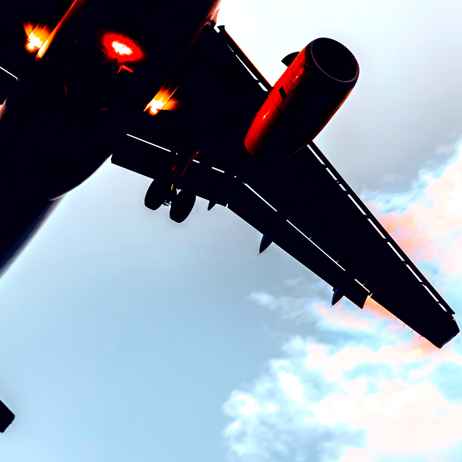 Close up view from below of an airplane flying upwards.