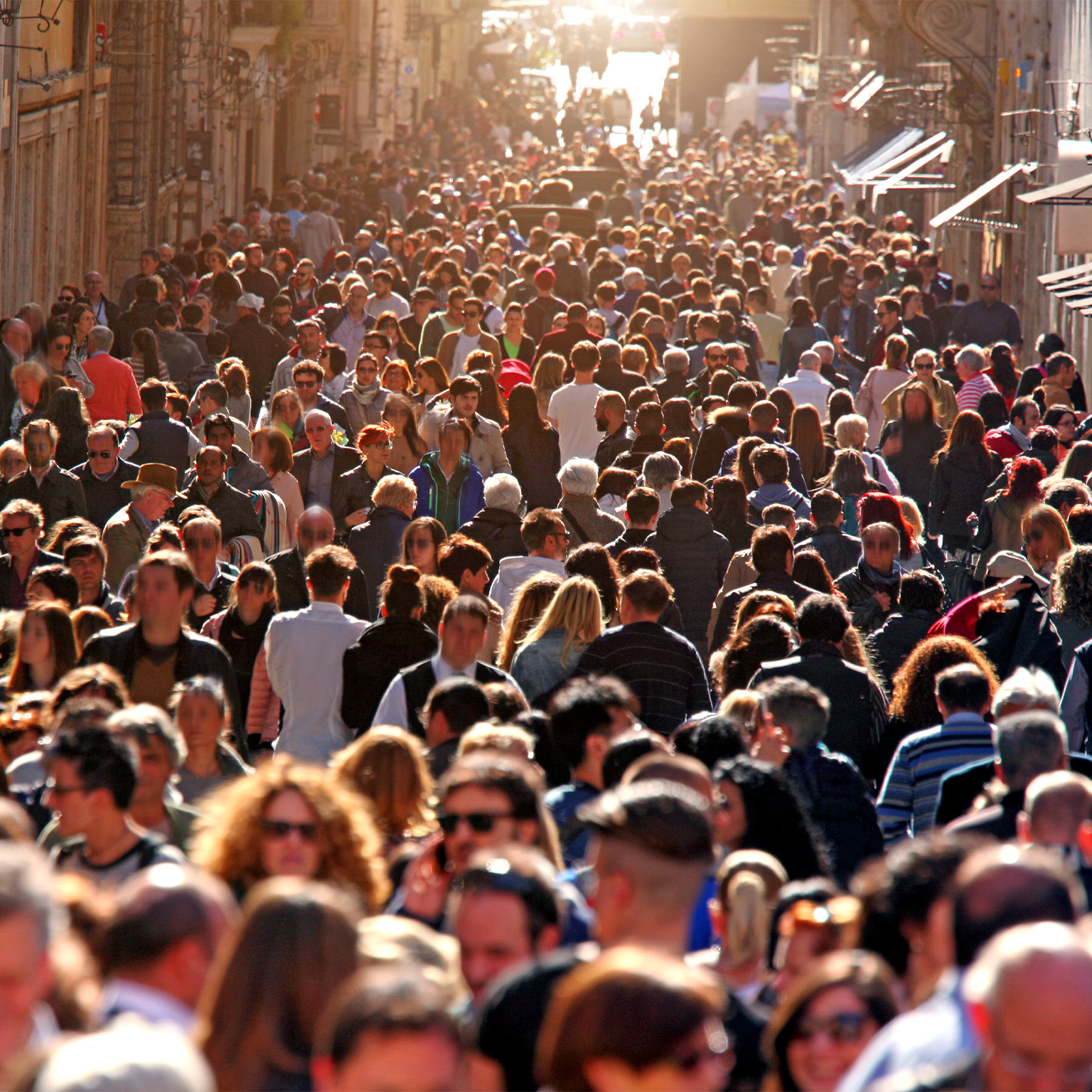 Image of large group of people crowding Rome's downtown streets in a sunny day.