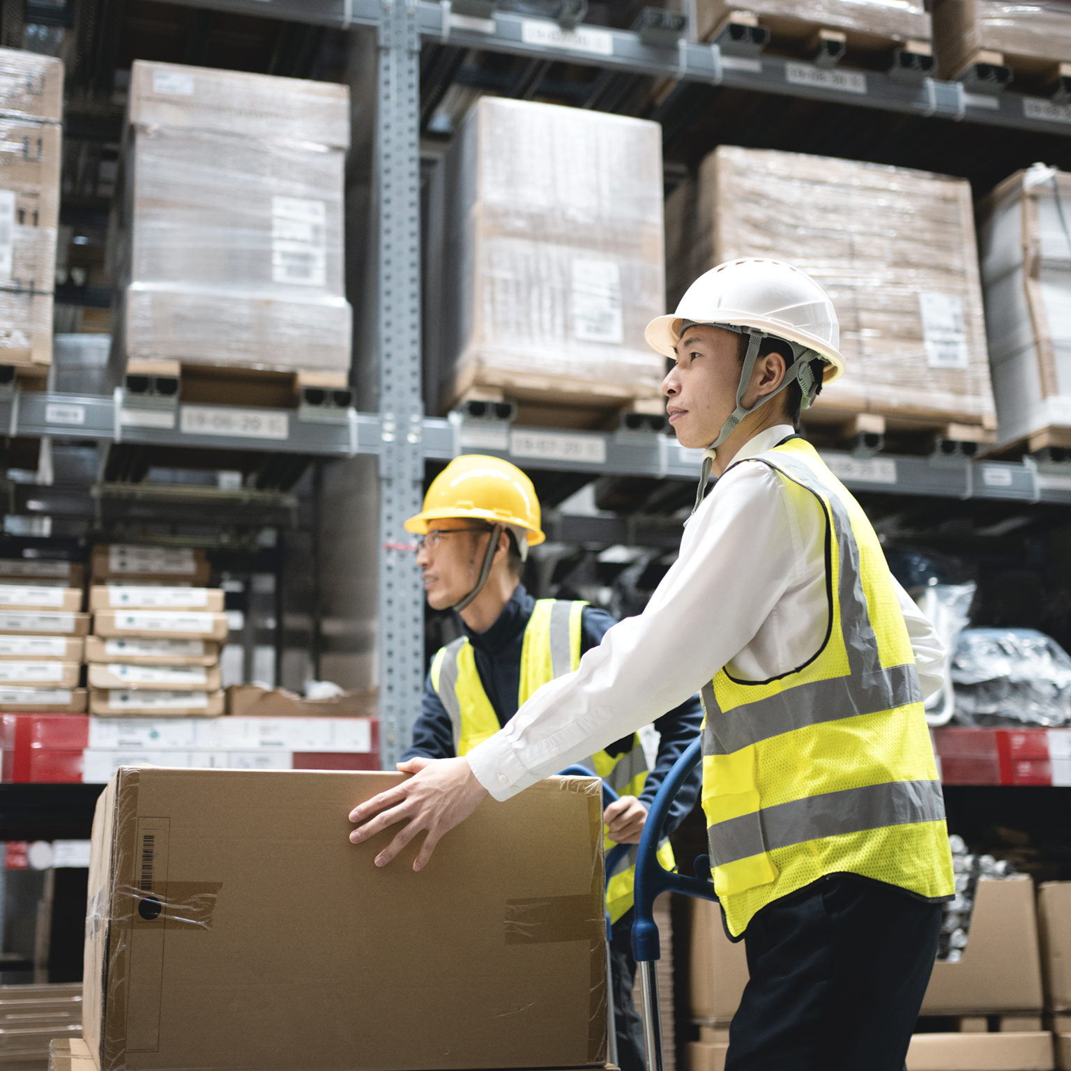 Two workers moving goods in a warehouse