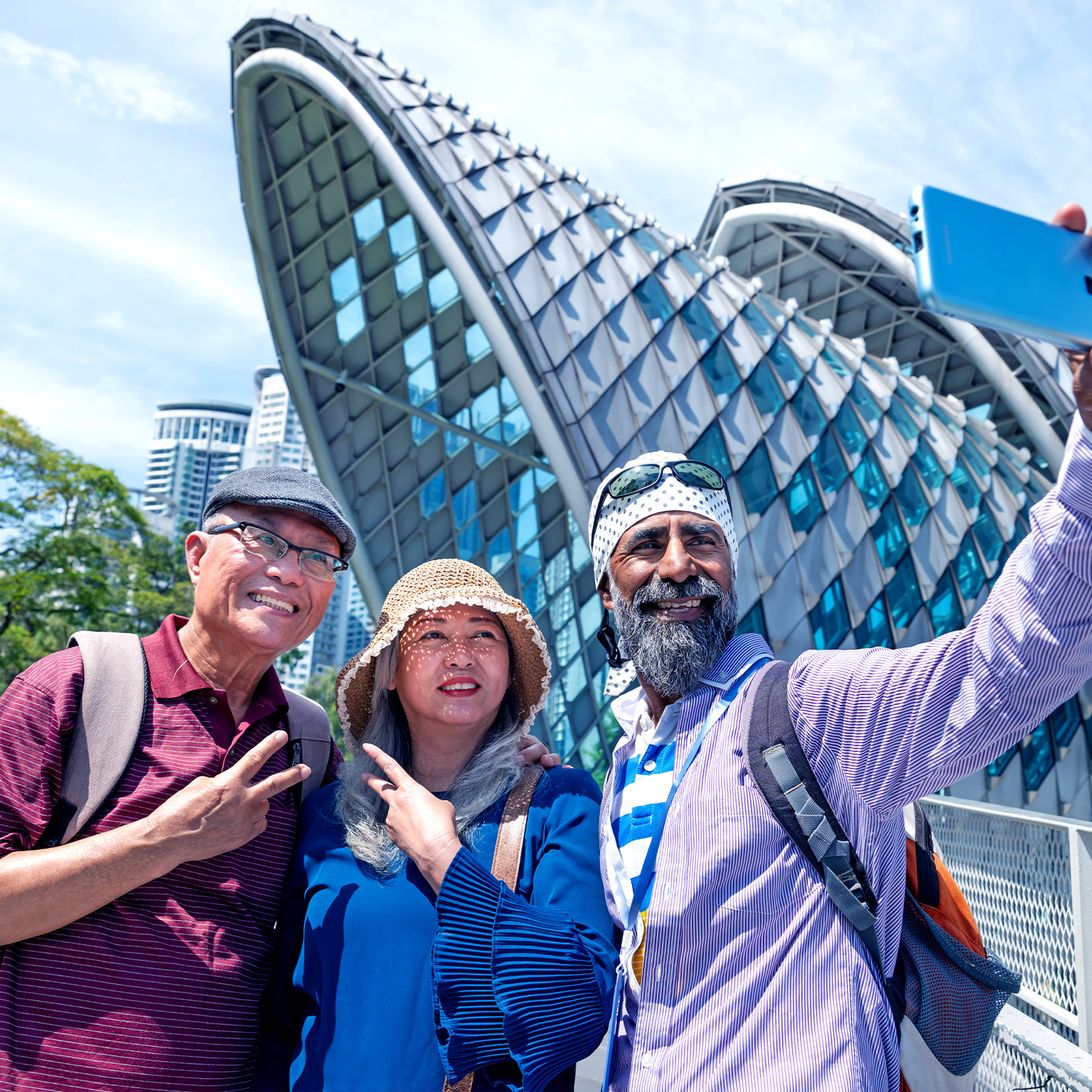 Image of two lovely senior Asian traveler having holiday photo taken by the Sikh tour guide in front of the Saloma Bridge, Kuala Lumpur.