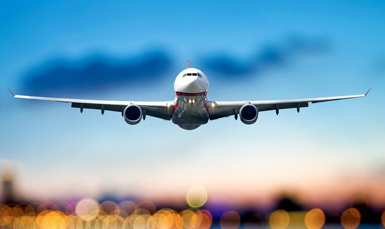 Commercial airplane taking off, airport lights are blurred in the background
