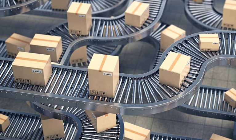 Cardboard boxes on conveyor roller in distribution warehouse
