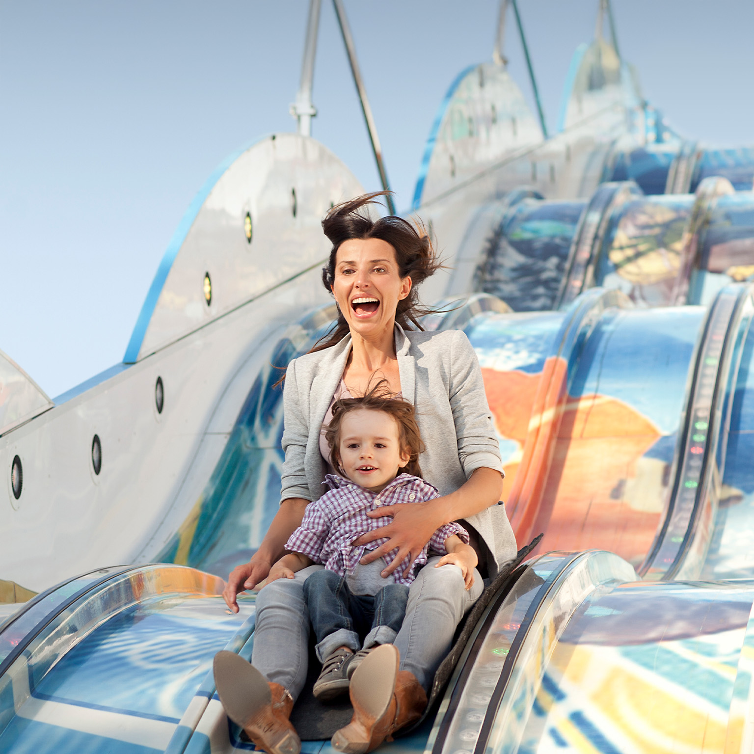 Mother and her son on a slide at the carnival